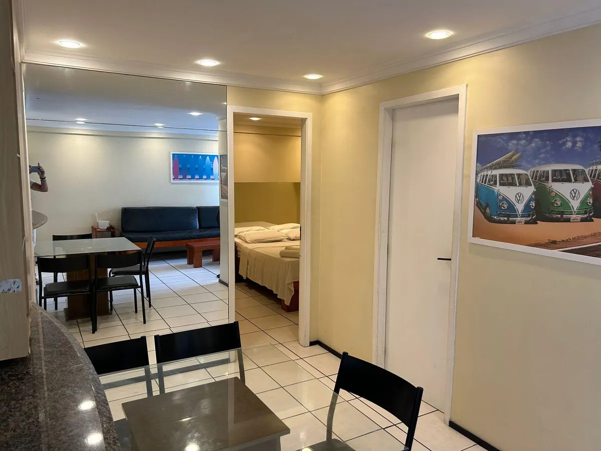 Interior del apartamento con mesa de comedor, salón y acceso al dormitorio