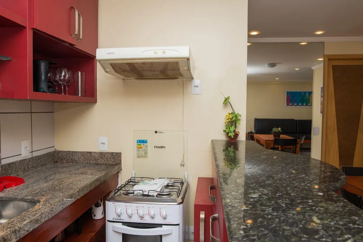 Encimera de la cocina con la cocina y la campana, con vista al salón