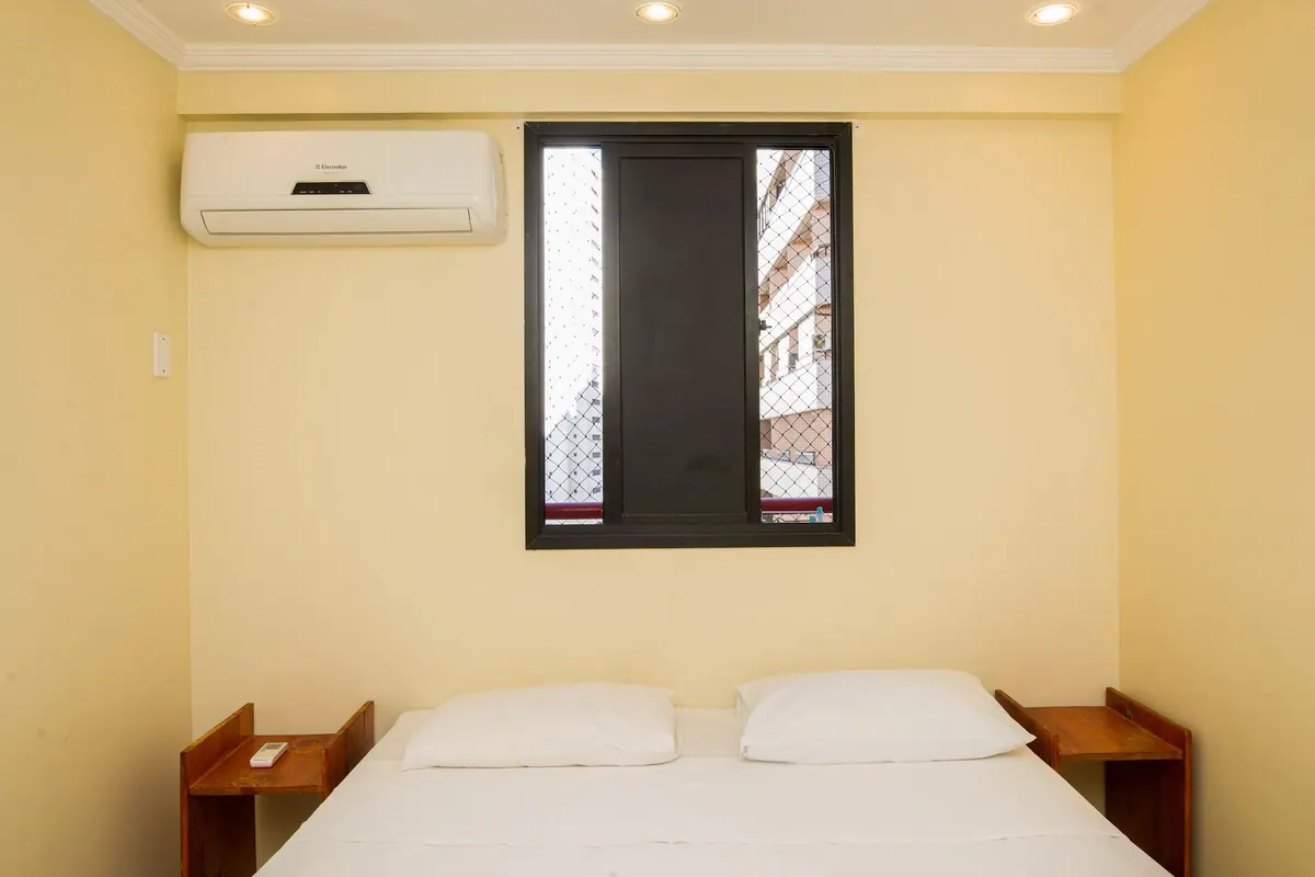 Segundo dormitorio con cama queen, mesitas de noche y aire acondicionado split
