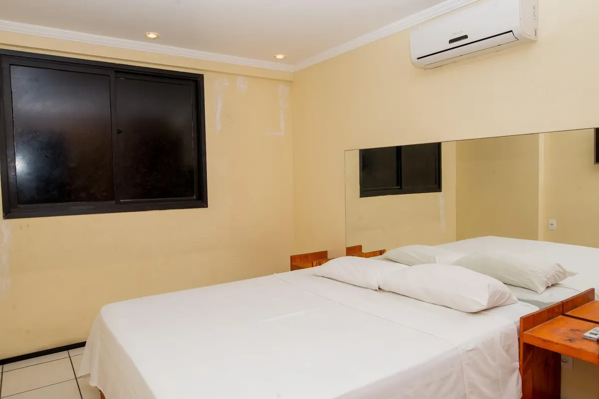 Suite con cama queen, aire acondicionado split y ventana amplia