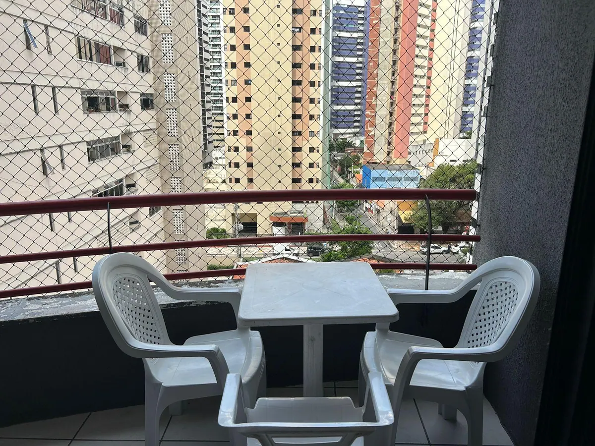 Balcón privado del apartamento con mesa, sillas y vistas al barrio de Meireles